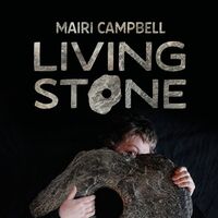 Mairi holding a large stone on a black background
